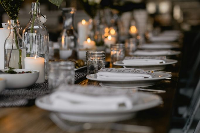 Elegant gedeckter Tisch mit Tellern, Kerzen und Dekorationen für ein festliches Abendessen.